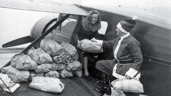 Edward Rowe Snow and his wife Anna load an airplane full of Christmas packages for their annual Flying Santa trip in 1963